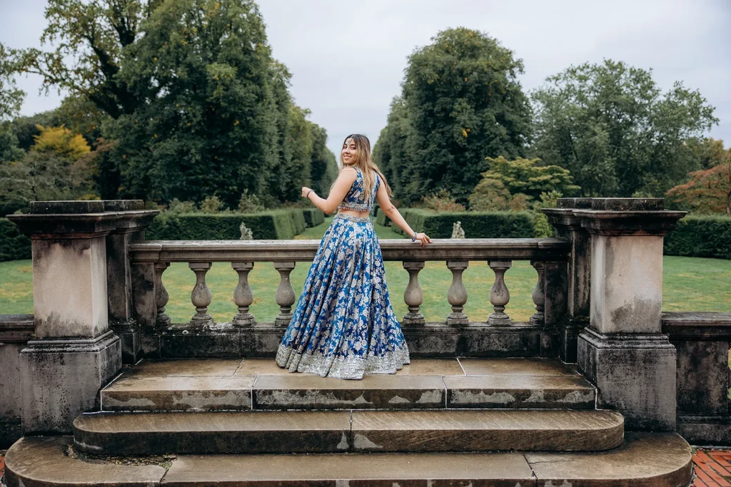 Woman in a blue formal dress posing in the gardens at Untermyer Park and Gardens in Yonkers, New York